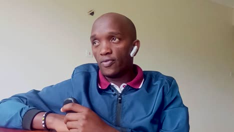 África-Joven-Hombre-Hablando-Por-Teléfono-Celular-En-Bluetooth-Inalámbrico-En-Nairobi-África