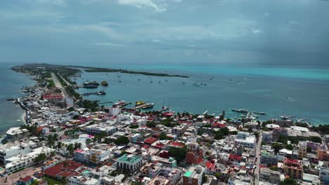 Aerial-view-over-the-cityscape,-harbor-and-boats-of-sunny-Isla-Mujeres,-Mexico