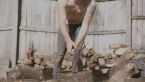 Centered-close-up-slow-motion-footage-of-a-log-being-split-by-a-axe-wielding-man