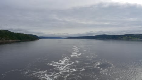 Vista-De-Las-Montañas-Desde-La-Popa-De-Un-Barco-Que-Navega-A-Lo-Largo-Del-Fiordo-De-Saguenay-Fuera-De-La-Baie,-Qc,-Canadá