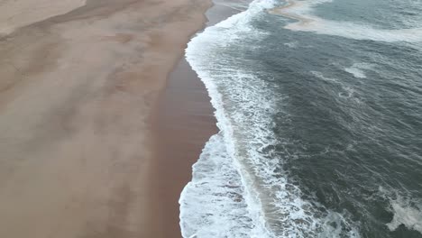 Ocean-waves-breaking-on-empty-coastal-beach,-near-porto-portugal-coastline
