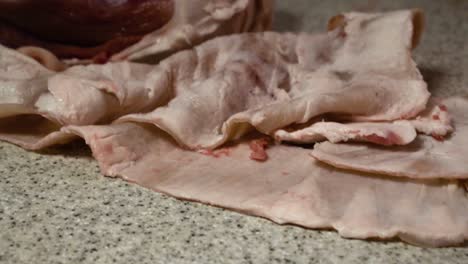 Nahaufnahme-Eines-Schweinefleisch-Trennprozesses-Auf-Einem-Küchentisch-In-Zeitlupe-Nach-Oben-Kippen