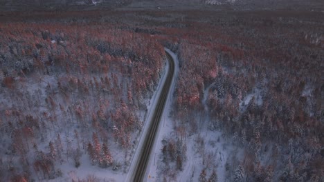 Vista-Panorámica-De-La-Carretera-Remota-En-Bosques-De-Matorrales-Durante-El-Invierno-Al-Atardecer-En-El-Sur-De-Quebec,-Canadá