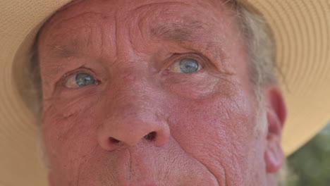 Closeup-face-of-old-man-70s-with-blue-eyes,-looking-into-the-distance