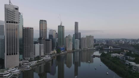 Filmische-Drohne-über-Den-Fluss-In-Richtung-Brisbane-City-Bei-Sonnenaufgang