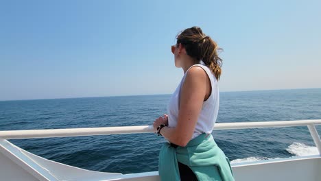 Schöne-Weibliche-Reisende-Auf-Einer-Yacht-Setzt-Eine-Sonnenbrille-Auf-Und-Bewundert-An-Einem-Sonnigen-Tag-Den-Ruhigen-Blauen-Ozean