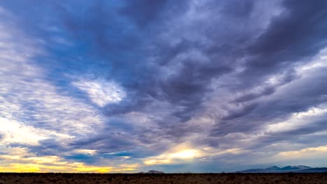 Die-Goldenen-Farben-Eines-Mojave-Wüstensonnenuntergangs-Beleuchten-Den-Himmel-In-Dieser-Rauen-Wildnis-Mit-Bergen-In-Der-Ferne---Zeitraffer-Wolkenlandschaft