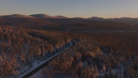 Camino-Forestal-De-Invierno---Camino-De-Montaña-Cubierto-De-Nieve-Durante-La-Puesta-De-Sol-En-El-Sur-De-Quebec,-Canadá---Toma-Aérea-De-Drones