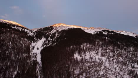 Sunset-hitting-the-peak-of-a-snow-covered-mountain-during-golden-hour