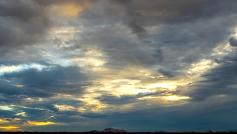 Golden-sunset-over-a-Mojave-Desert-butte-in-silhouette---dynamic-cloudscape-time-lapse