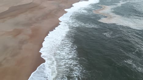 Ocean-waves-breaking-on-empty-coastal-beach,-near-porto-portugal-coastline