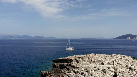 Yacht-Sailing-On-The-Calm-Ocean-Of-Paralia-Emplisi-In-Fiskardo,-Erisos-Greece