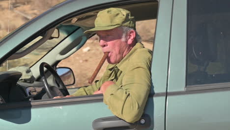 Old-man-in-SUV-with-cigar-in-his-mouth-drives-by,-off-roading