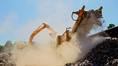 Slow-Motion-shot-of-crane-and-conveyor-transporting-rocks-and-sand-with-dust-in-sunlight---low-angle
