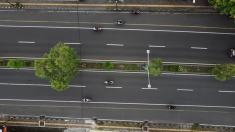 Aerial-top-down-view-of-asphalt-road-with-car-traffic-in-city-in-summer-evening,-drone-shot