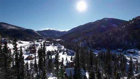 Drone-aerial-view-over-trees-in-a-valley-on-a-sunny-day-in-the-winter