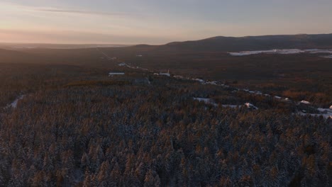 Bosque-De-Coníferas-Cubierto-De-Nieve-Durante-La-Puesta-De-Sol-En-El-Sur-De-Quebec,-Canadá---Toma-Aérea-De-Drones
