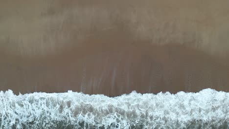 Top-down-birdseye-view-ocean-waves-breaking-on-coast,-porto-portugal-city