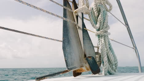 Closeup-of-Danforth-anchor-on-sailboat-deck,-sailing,-handheld,-day
