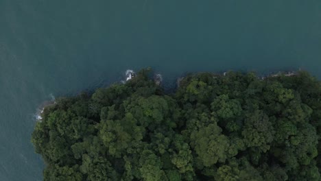 Aerial-high-angle-view-trucking-sideways-along-the-lush-and-rugged-coast-line-of-Manuel-Antonio