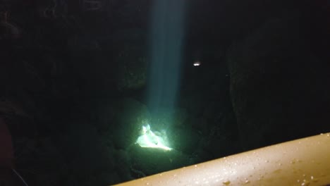 Kajakfahrer-Beobachtet-Einen-Lichtstrahl,-Der-Auf-Einigen-Felsen-Im-Wasser-In-Einer-Meereshöhle-Reflektiert-Wird,-Gegenüber-Der-Insel,-Adria,-Kroatien