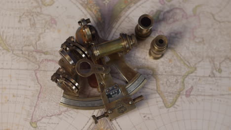 A-brass-sextent-navigation-instrument-on-a-vintagemap-of-the-world