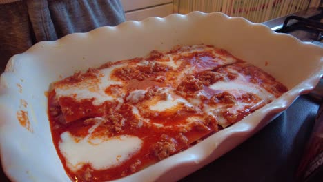 Cheese-Being-Sprinkled-On-Top-Of-Bechamel-And-Bolognese-Sauce-In-Lasagne-Dish-By-Hand