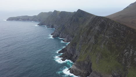 Cinematic-rotating-drone-shot-of-the-rocky-mountain-coastline-at-Keem-Beach,-Ireland-on-the-Wild-Atlantic-Way