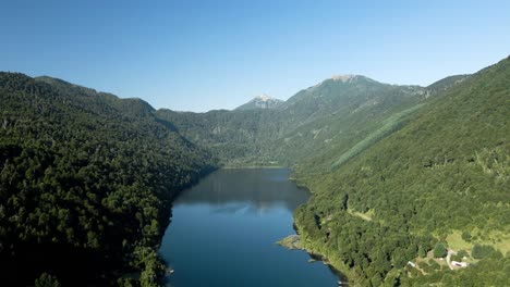 Aerial-view-of-tinquilco-lake-in-Huerquehue-National-Park,-Chile-on-a-sunny-day-surrounded-by-a-mixed-forest---drone-shot