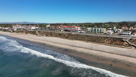 Aerial-drone-view-from-over-the-sea-beach-of-the-Carlsbad-California-Beach-Town-in-USA-on-a-bright-sunny-day