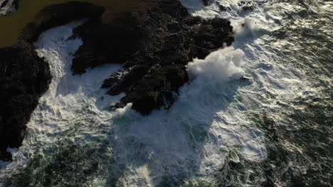 Down-tilt-cinematic-drone-shot-of-the-White-Cliffs-of-Ashleam,-Ireland-with-waves-crashing