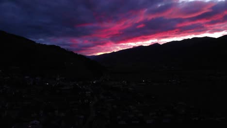 Aerial-Sunset-View-Over-Kaprun-In-Austria-With-Silhouetted-Mountains-Against-Dramatic-Purple-Pink-Clouds