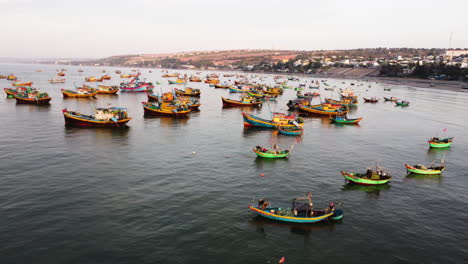 Early-morning-drone-flight-in-Mui-Ne-bay,-which-is-filled-with-colourful-fishermen-boats