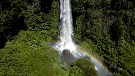 General-view-of-Salto-el-León-in-Pucón,-Chile-with-a-rainbow-generated-by-the-abundant-falling-water---drone-shot
