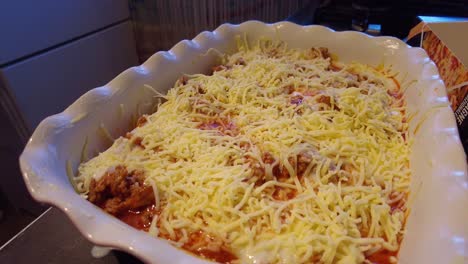 Mozzarella-Cheese-Being-Added-And-Sprinkled-Into-Lasagne-Dish-By-Hand
