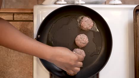 Putting-ground-lamb-balls-into-a-frying-pan-to-make-spiced-patties---overhead-view-LAMB-PATTY-SERIES