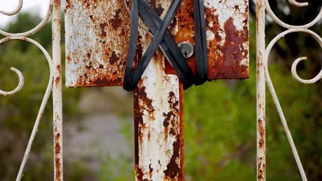 An-old-rusty-fence-with-a-lock-tied-and-wired-shut-to-discourage-trespassers---grunge-look