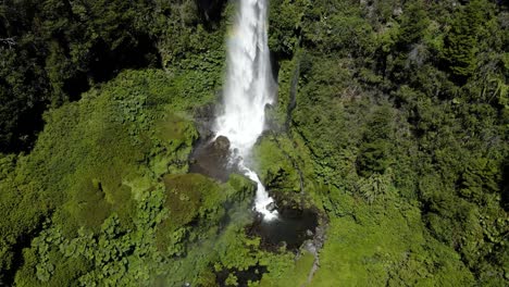 Drone-shot-of-the-waterfall-at-El-Salto-El-Leon-surrounded-by-vegetation-and-with-a-rainbow---crane-shot