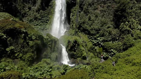 Dolly-in-El-Leon-waterfall-in-Pucon-with-abundant-water-falling-in-a-place-with-a-lot-of-vegetation---drone-shot