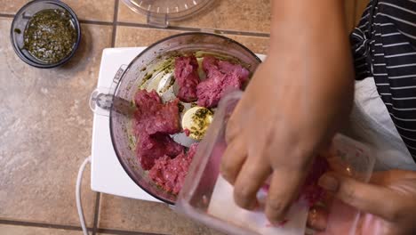 Placing-ground-lamb-meat-into-a-food-processor-to-mix-in-with-herbs---overhead-view-LAMB-PATTY-SERIES