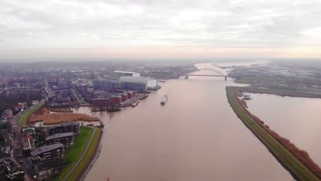 High-Aerial-View-Over-River-Noord-On-Cloudy-Day-With-Strelitzia-Cargo-Shop-Passing-Crezeepolder-In-Alblasserdam