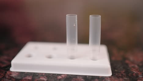 Solution-drops-are-squeezed-into-a-tube-for-a-COVID-19-rapid-test,-slow-motion