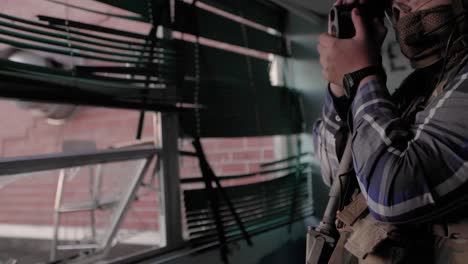 Militärischer-Auftragnehmer-Mit-Zielfernrohrgewehr-Und-Taktischer-Tarnausrüstung-überwachung-Zerbrochenes-Fenster-Verlassenes-Gebäude