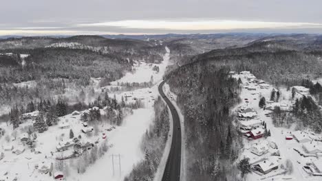 Cars-Driving-On-Long-And-Winding-Highway-Through-Wintry-Landscape-In-Norway