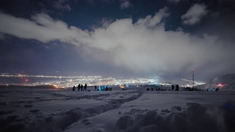 People-in-snow-enjoy-scenic-vantage-point-over-Tromso