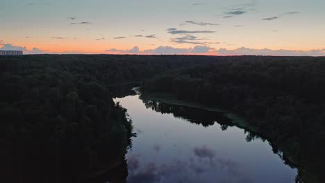 Flight-Over-River-Mirror-Surface-Among-Dark-Forest-At-Evening-Dusk