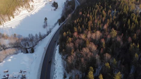 Top-View-Of-Snow-Covered-Forest-With-Winter-Road---aerial-drone-shot