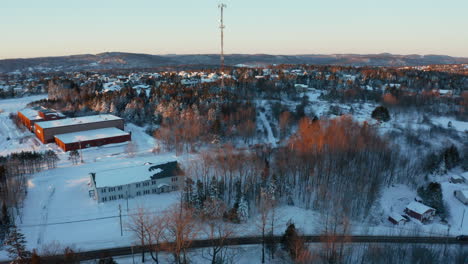 Picturesque-winter-aerial-flying-toward-a-cell-site-tower-in-a-snow-covered-neighborhood