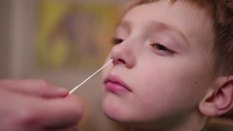 A-little-boy-getting-a-nasal-swab-as-part-of-an-at-home-rapid-response-covid-19-test