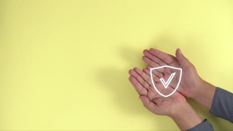 hands-together-show-protection-shield-on-yellow-background